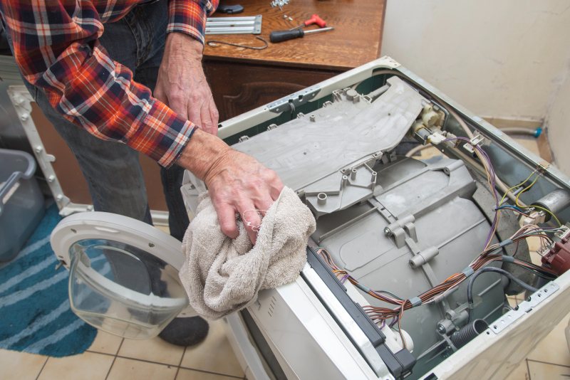 Technician repairing washing machine at home