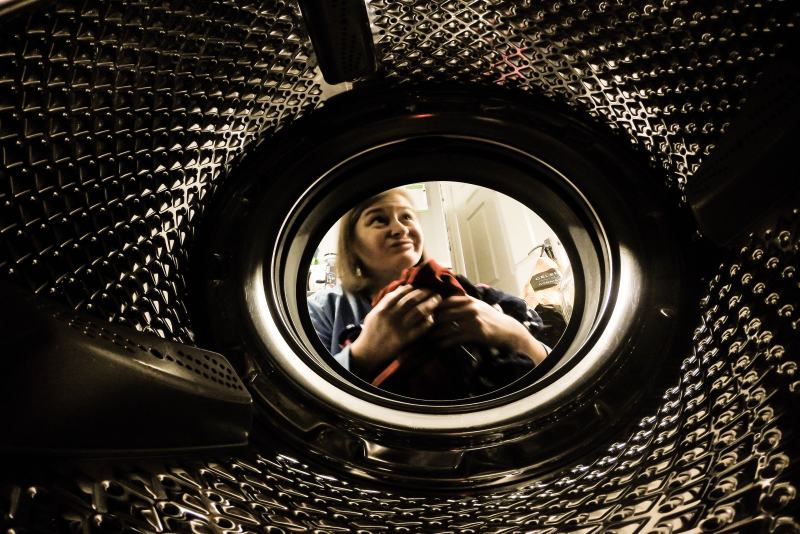 Woman smiling from inside of washing machine